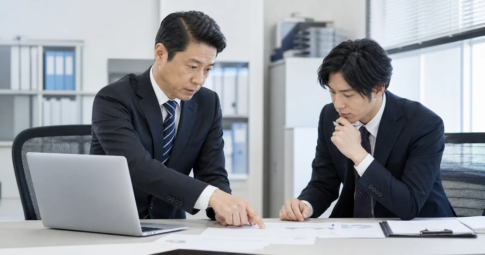 経営者と経理スタッフが月次の作業予定をホワイトボードで確認している様子